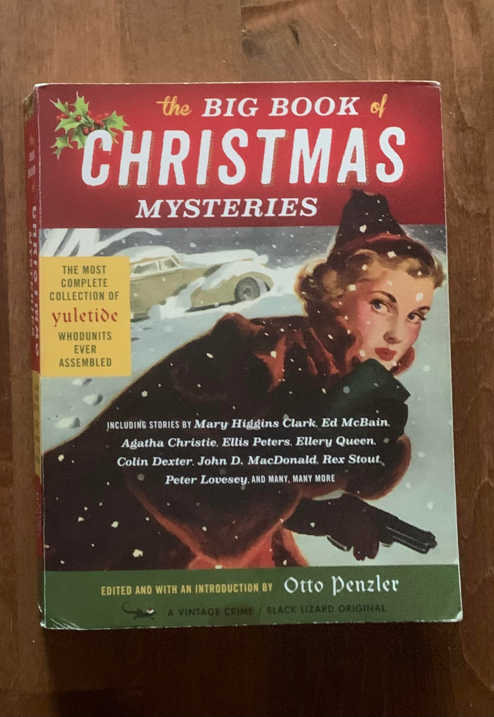 The Big Book of Christmas Mysteries, which features an early twentieth-century magazine illustration of a young woman in a fur coat in the snow, carrying a gun. It also lists a bunch of the authors included in the book.